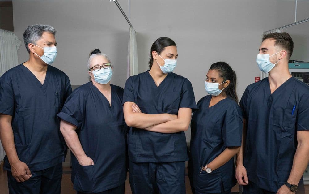 Five doctors in scrubs and masks 